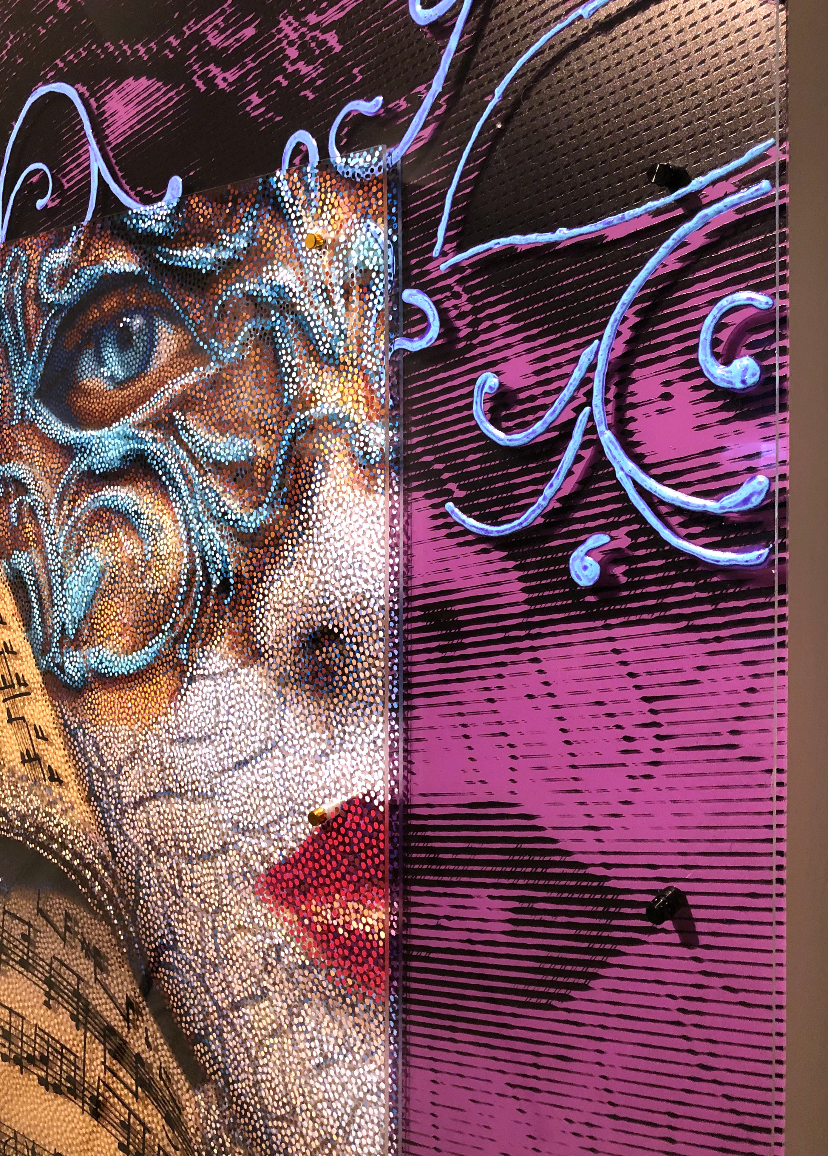 Volto Musica – Side detail of layered plexiglass, mask, and blue scrollwork