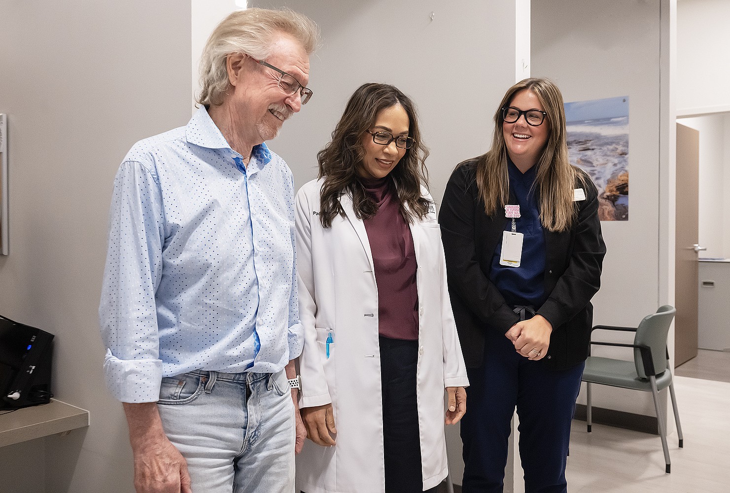 Robert Shirk, Dr. Padmaja Sai, and Alexandra Adona looking at the donated painting